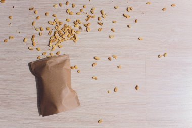 Kabuk içinde fıstık dökülen kahverengi torba.