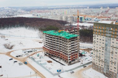 Büyük şehirde yüksek katlı konut inşaatı. Günbatımı kış Cityscape.