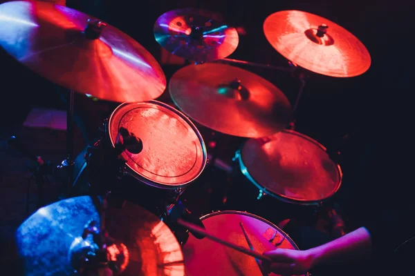 Drummer playing drum set at concert on stage. Music show. Bright scene lighting in club,drum sticks in hands. — Stock Photo, Image