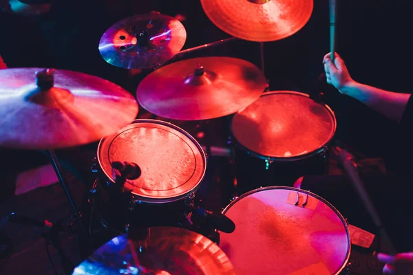 Drummer drumstel op concert op het podium. Muziekshow. Heldere scène verlichting in club, drum sticks in handen. — Stockfoto