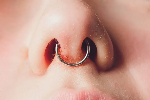 Macro close-up van een jonge vrouw visage met piercing opknoping van haar neus. — Stockfoto