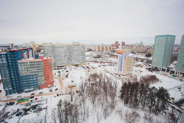 Construção de edifícios residenciais altos na cidade grande. A paisagem urbana de inverno ao pôr do sol . — Fotografia de Stock