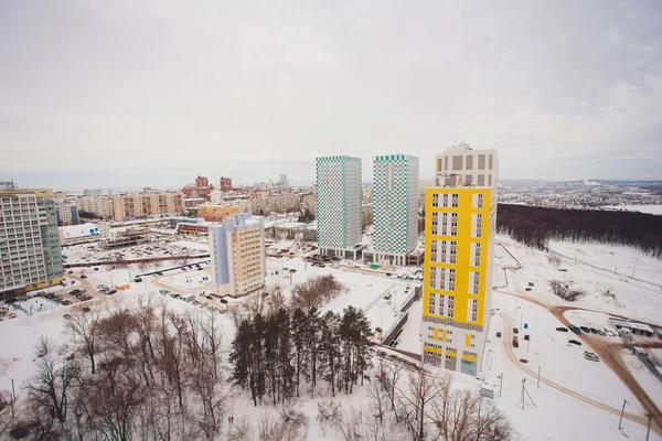 Byggande av höghus bostads hus i storstaden. Vinterstadsbilden vid solnedgången. — Stockfoto