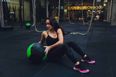 Kas kadın spor salonunda yoğun çekirdek egzersiz yapıyor. Güçlü kadın sağlık kulübünde tıp topu ile Fitness mat çekirdek egzersiz yapıyor.