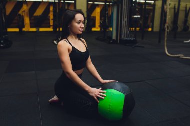 Kas kadın spor salonunda yoğun çekirdek egzersiz yapıyor. Güçlü kadın sağlık kulübünde tıp topu ile Fitness mat çekirdek egzersiz yapıyor.