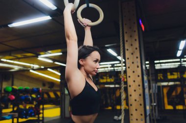 Spor salonu jimnastik halkaları üzerinde egzersiz genç atletik sporcumuz.