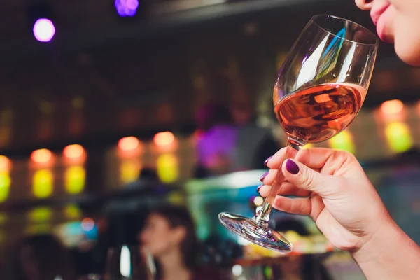 Una copa de vino en hermosas manos femeninas. Gran vaso lleno de vino tinto en las manos manicura mujer. Concepto de romance y celebración . —  Fotos de Stock