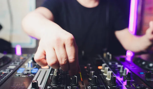 Närbild av händerna på manliga discjockey blanda musik på hans däck med händerna redo över vinylskivan på skivspelare och kontroll brytare på natten. — Stockfoto