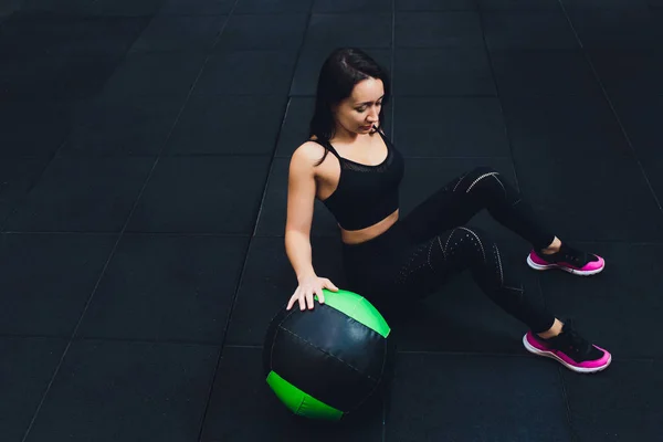 Gespierde vrouw doet intense core workout in Gym. Sterke vrouwelijke doen kern oefening op fitness mat met geneeskunde bal in Health Club. — Stockfoto