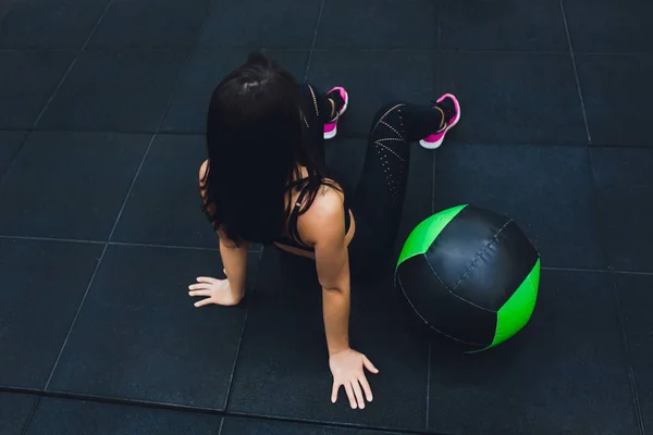 Gespierde vrouw doet intense core workout in Gym. Sterke vrouwelijke doen kern oefening op fitness mat met geneeskunde bal in Health Club. — Stockfoto