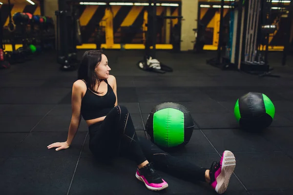 Gespierde vrouw doet intense core workout in Gym. Sterke vrouwelijke doen kern oefening op fitness mat met geneeskunde bal in Health Club. — Stockfoto