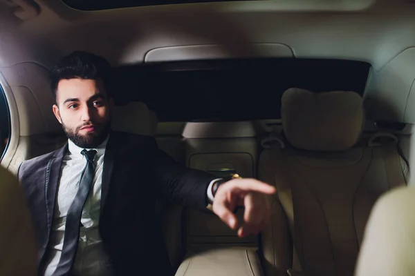 Retrato del hombre de negocios conduciendo en coche y sonriendo en su viaje matutino al trabajo. Joven su dedo apuntando hacia la cámara . —  Fotos de Stock