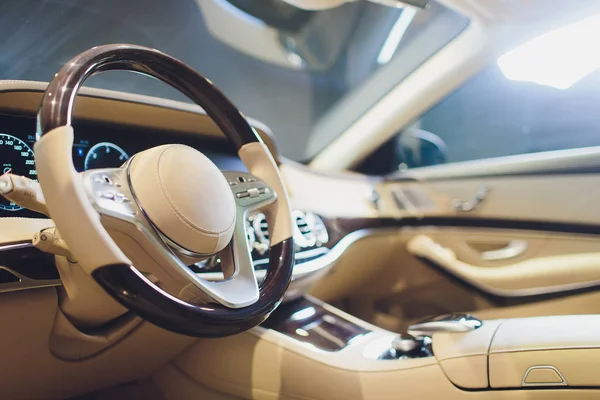 White leather interior of the luxury modern car. Leather comfortable white seats and multimedia. Steering wheel and dashboard. Automatic gear stick. Modern car interior details.