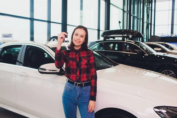 Mulher motorista segurando chaves do carro. Sala de exposições do carro . — Fotografia de Stock