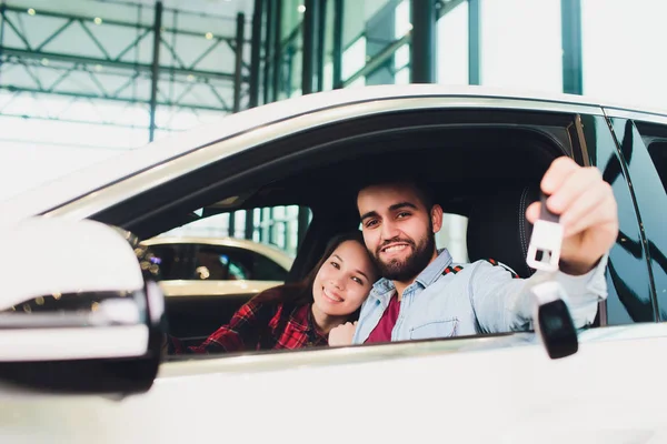 Guapo hombre de mediana edad mostrando una llave de coche dentro de su nuevo vehículo . —  Fotos de Stock