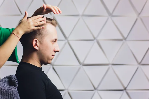 Cabeleireiro fêmea secando seus clientes masculinos cabelo em seu salão de cabeleireiro . — Fotografia de Stock