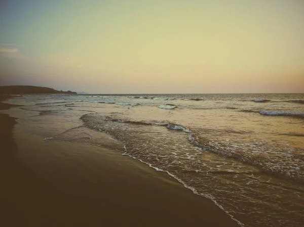 Sonnenuntergang über dem Ozean. Sandstrand wird abends in leuchtenden Farben gestrichen. — Stockfoto