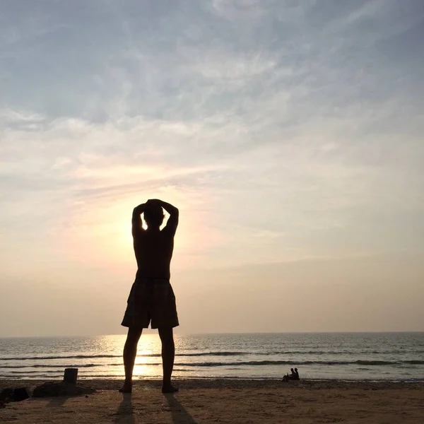 L'uomo con le mani alzate a guardare il tramonto . — Foto Stock