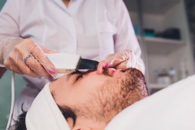 Ultrasonik yüz kaydırma kapatın. Sağlıklı genç adam, kozmetoloji.