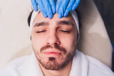 Kadın eller temizlik Mans yüz pamuk bezlerden ile bir spa merkezi.