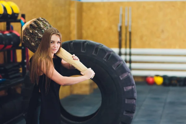 Fit vrouwelijke atleet uit te werken met een enorme band, draaien en uitvoeren in de sportschool. vrouw oefenen met grote band. — Stockfoto
