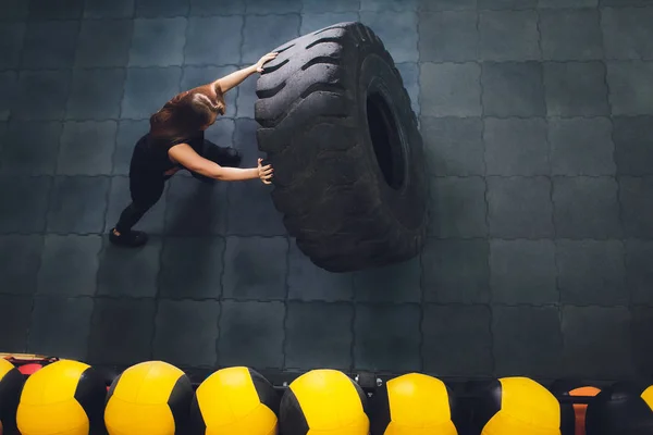 거 대 한 타이어와 함께 밖으로 작업 하는 여성 선수에 맞게, 켜고 체육관에서 수행. 큰 타이어로 운동 하는 여자. — 스톡 사진