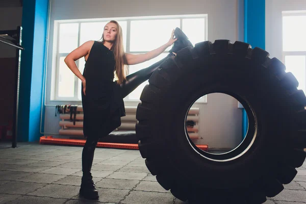 Fit vrouwelijke atleet uit te werken met een enorme band, draaien en uitvoeren in de sportschool. vrouw oefenen met grote band. — Stockfoto