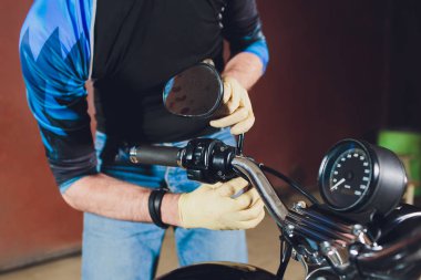 Adam bisikleti onariyor. Onun garajına yakın motosiklet tamir emin genç adam. dikiz aynası ayarlaması.