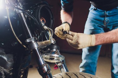 Adam bisikleti onariyor. Onun garajına yakın motosiklet tamir emin genç adam. Far içinde yedek lamba