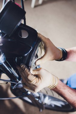 Adam bisikleti onariyor. Onun garajına yakın motosiklet tamir emin genç adam. Far içinde yedek lamba