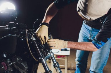 Adam bisikleti onariyor. Onun garajına yakın motosiklet tamir emin genç adam. Far içinde yedek lamba