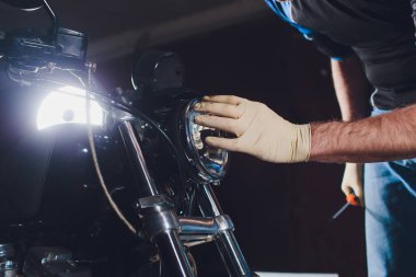 Adam bisikleti onariyor. Onun garajına yakın motosiklet tamir emin genç adam. Far içinde yedek lamba