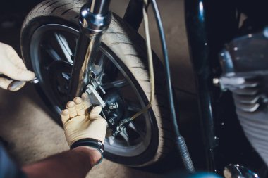 Adam bisikleti onariyor. Onun garaj yakınında motosiklet tamir emin genç adam.