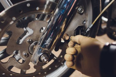 Adam bisikleti onariyor. Onun garaj yakınında motosiklet tamir emin genç adam.