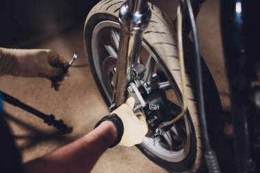 Adam bisikleti onariyor. Onun garaj yakınında motosiklet tamir emin genç adam.