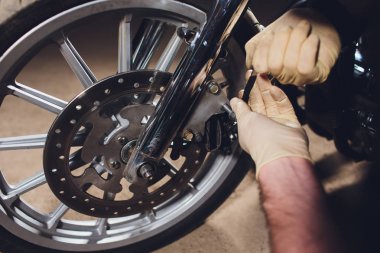 Adam bisikleti onariyor. Onun garaj yakınında motosiklet tamir emin genç adam.