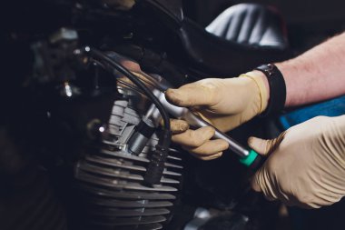 Adam bisikleti onariyor. Onun garaj yakınında motosiklet tamir emin genç adam.