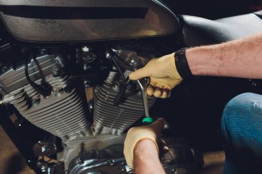 Adam bisikleti onariyor. Onun garaj yakınında motosiklet tamir emin genç adam.