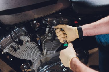 Adam bisikleti onariyor. Onun garaj yakınında motosiklet tamir emin genç adam.