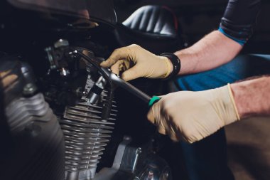 Adam bisikleti onariyor. Onun garaj yakınında motosiklet tamir emin genç adam.