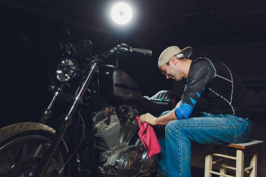 Adam bisikleti onariyor. Onun garaj yakınında motosiklet tamir emin genç adam.