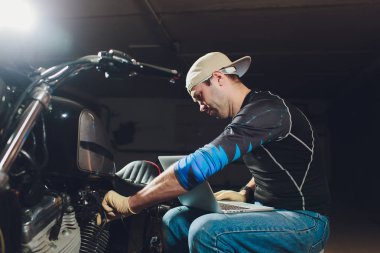 Denetçiler rehberlik altında motosiklet tamircisi tamir motoru. video kamera, dizüstü makine kontrol etmek için motorun içini görmek için.