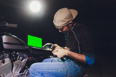 Denetçiler rehberlik altında motosiklet tamircisi tamir motoru. video kamera, dizüstü makine kontrol etmek için motorun içini görmek için.