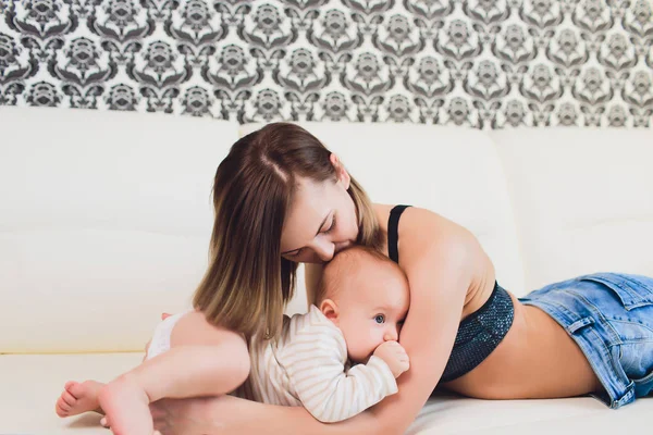 A Mother and baby child on a white bed. — Stock Photo, Image