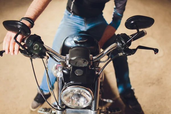 Pria memperbaiki sepeda. Anak muda yang percaya diri memperbaiki sepeda motor di dekat garasinya . — Stok Foto