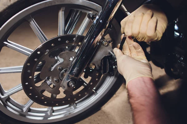 Adam bisikleti onariyor. Onun garaj yakınında motosiklet tamir emin genç adam.