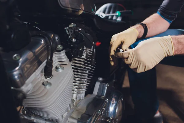 Adam bisikleti onariyor. Onun garaj yakınında motosiklet tamir emin genç adam.