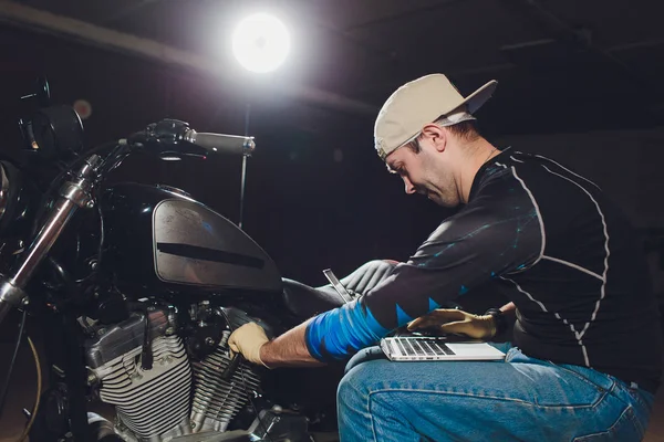 Denetçiler rehberlik altında motosiklet tamircisi tamir motoru. video kamera, dizüstü makine kontrol etmek için motorun içini görmek için.