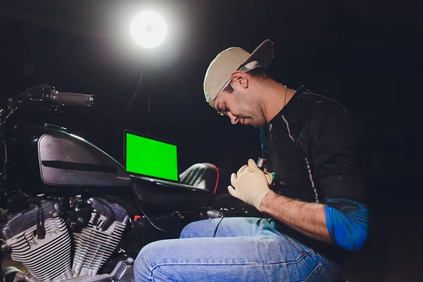 Denetçiler rehberlik altında motosiklet tamircisi tamir motoru. video kamera, dizüstü makine kontrol etmek için motorun içini görmek için.