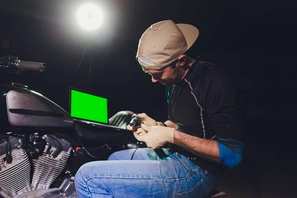 Denetçiler rehberlik altında motosiklet tamircisi tamir motoru. video kamera, dizüstü makine kontrol etmek için motorun içini görmek için.